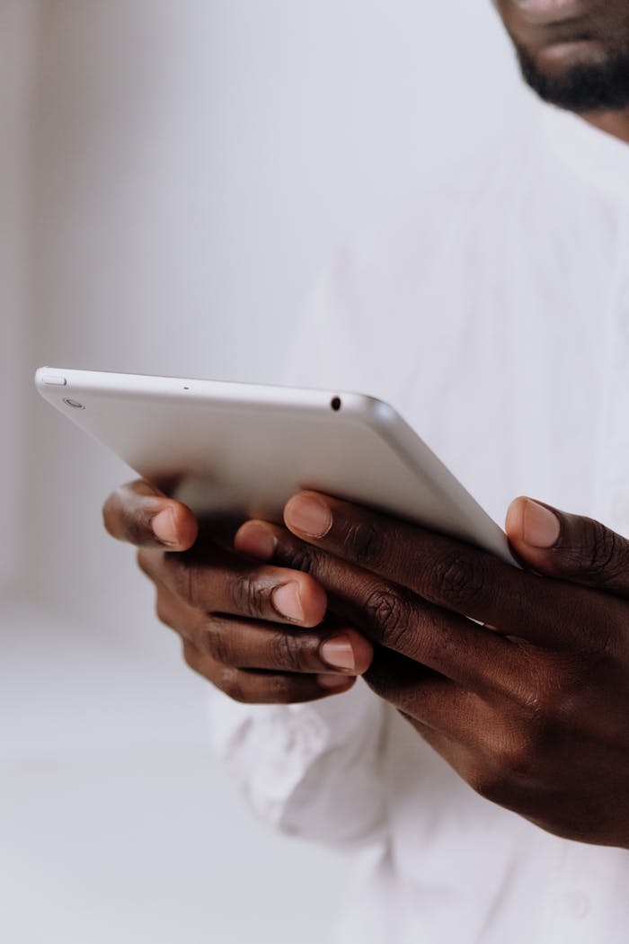 about-01 Professional holding a tablet, focusing on hands and technology in a bright setting.